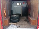 a red van with a tire in the back of it