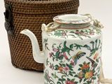 a tea pot and a basket sitting next to each other