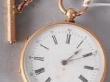 a gold pocket watch with a chain attached to it