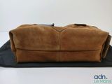 the large brown bag is sitting on a black mat