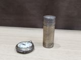 a small silver pocket watch next to a small silver pocket watch