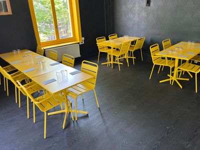 des tables et des chaises dans une pièce dotée d'une grande fenêtre et d'un mur noir