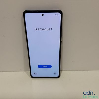 un gros plan d'un téléphone portable posé sur une table, avec une pancarte sur laquelle on peut lire « bienvenue »