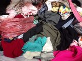 un gros tas de vêtements dans une valise posée par terre