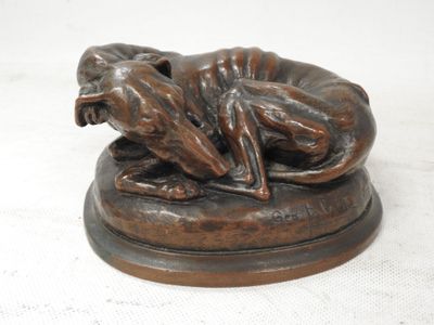 statue en bronze représentant un chien couché sur le dos sur un socle