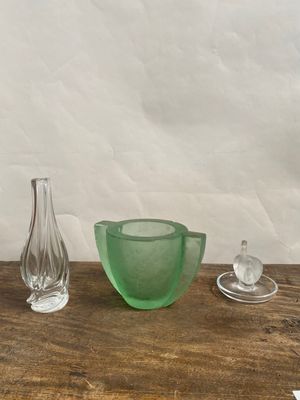 un saladier en verre vert et un vase en verre posés sur une table en bois
