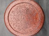 an overhead view of a red pot on a gray surface