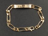 un gros plan d'un bracelet en or orné d'une plaque portant un nom