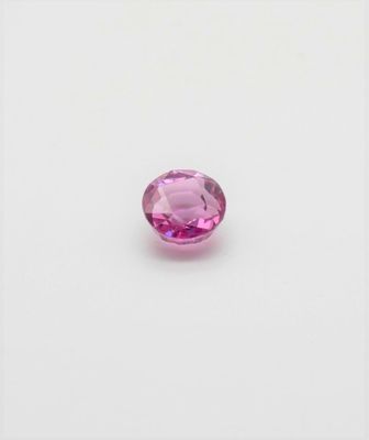 a pink tourmaline gems on a white surface