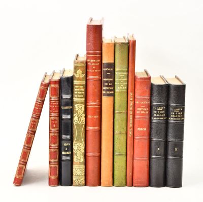 plusieurs vieux livres sont empilés sur une surface blanche