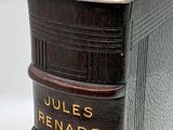 an old book sitting on top of a wooden table next to a white wall