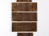 quatre morceaux de bois sculptés accrochés à un mur blanc