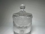 a clear glass jar with a lid on a white surface