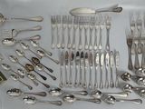 a lot of silver spoons and spoons on the table