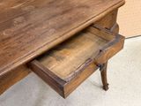 an old wooden desk with a drawer underneath it