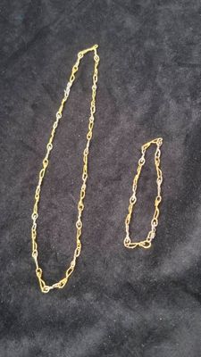 two pieces of gold chain on a black background