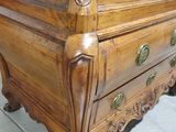 a wooden chest of drawers with brass knobs on it
