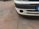 the front end of a white van parked in a garage