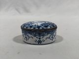 an old blue and white box with a flower design on it