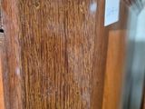 a close up of a wooden grandfather clock with a glass door