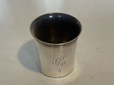 a silver cup sitting on a table with a white background