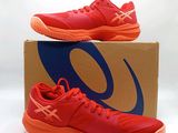 La chaussure est rouge et orange, avec un logo bleu sur le côté.