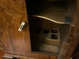 a wooden cabinet with a guitar in it on a wooden floor