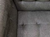 the grey couch is sitting in the corner of the room