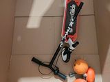 a red scooter in a cardboard box with oranges