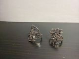 une paire de boucles d'oreilles plaquées argent ornées de feuilles, posées sur une table