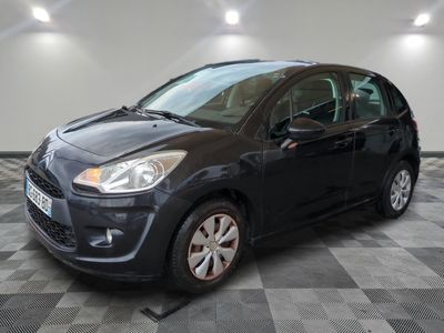 the small black car is parked on a checkered floor