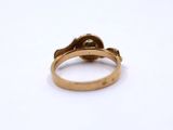 a close up of a gold ring on a white surface