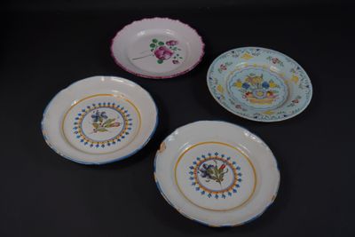 trois assiettes ornées de motifs floraux sont posées sur une surface noire