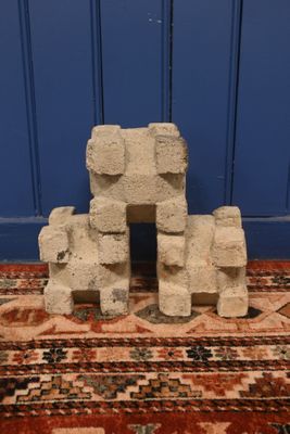 une pile de parpaings posée sur un tapis devant une porte bleue