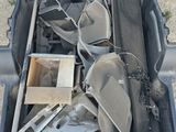 a suitcase full of items sitting on the ground next to a car