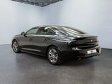 a black car is parked in a large room with white walls