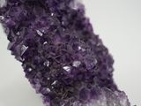 purple amethorate with white crystals on a rock on a white surface