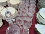 many plates and glasses on a table with a red table cloth