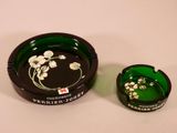 a green ashtray and a green ashtray on a white table