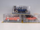 three toy cars in a display case on a table