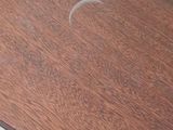 a wooden table with a circular top on a tile floor