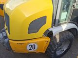 a yellow tractor that is parked next to other yellow trucks