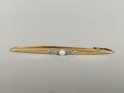 a close up of a gold tie bar with pearls on it