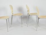 three white chairs sitting next to each other on a white surface