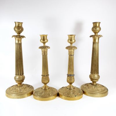 three brass candlesticks are sitting next to each other on a white surface