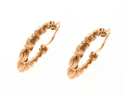 une image représentant une paire de boucles d'oreilles créoles en or sur fond blanc