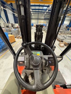 Le chariot élévateur se déplace dans l'entrepôt avec le siège du conducteur rabattu.