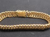 un bracelet en or sur une surface noire