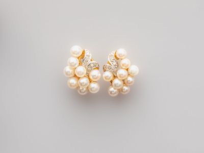 une paire de boucles d'oreilles en perles et diamants sur fond blanc