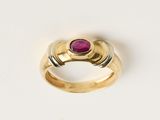 gros plan d'une bague en or avec une pierre en rubis